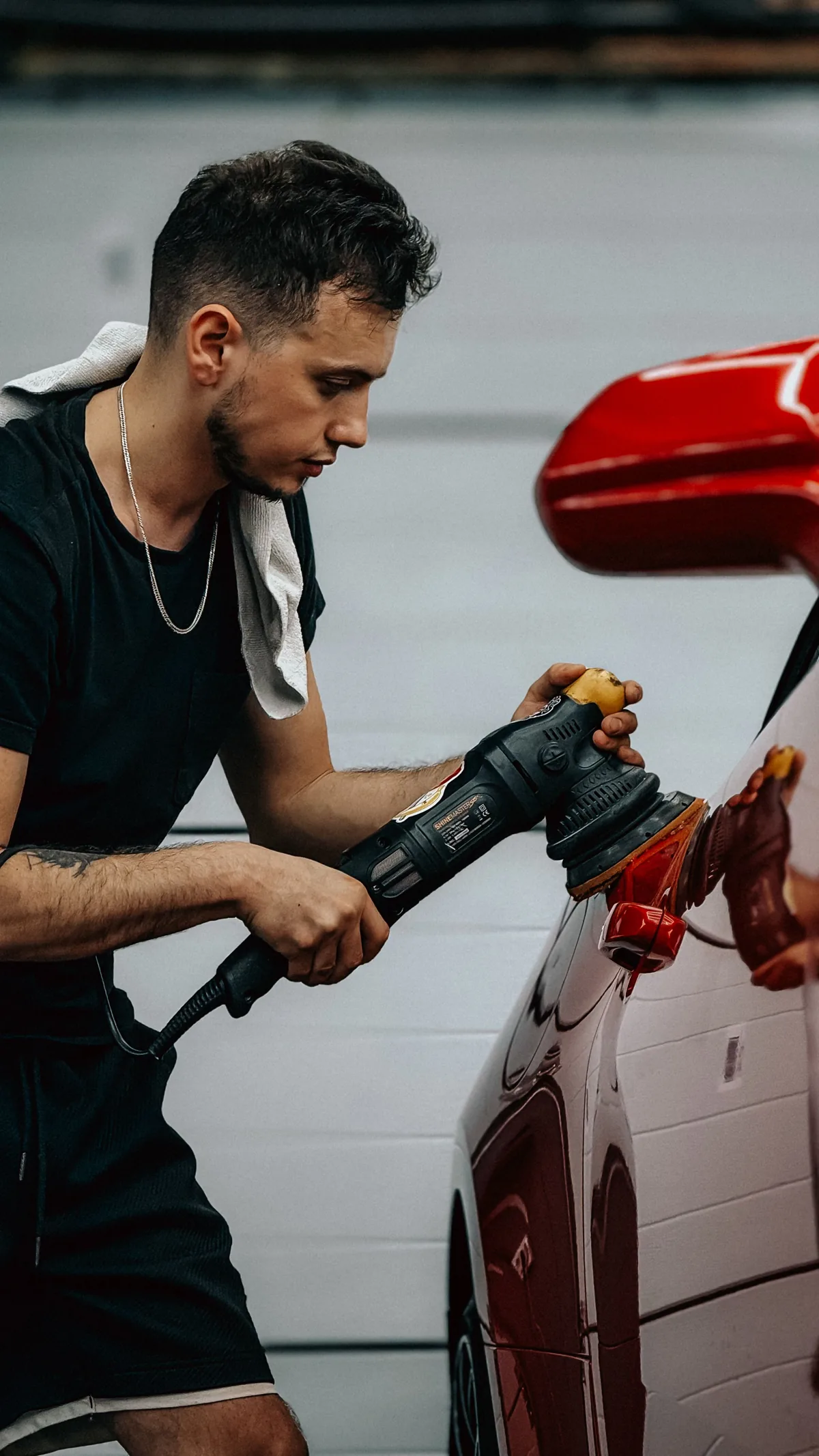 Technician machine polishing a panel to prep for ceramic coating