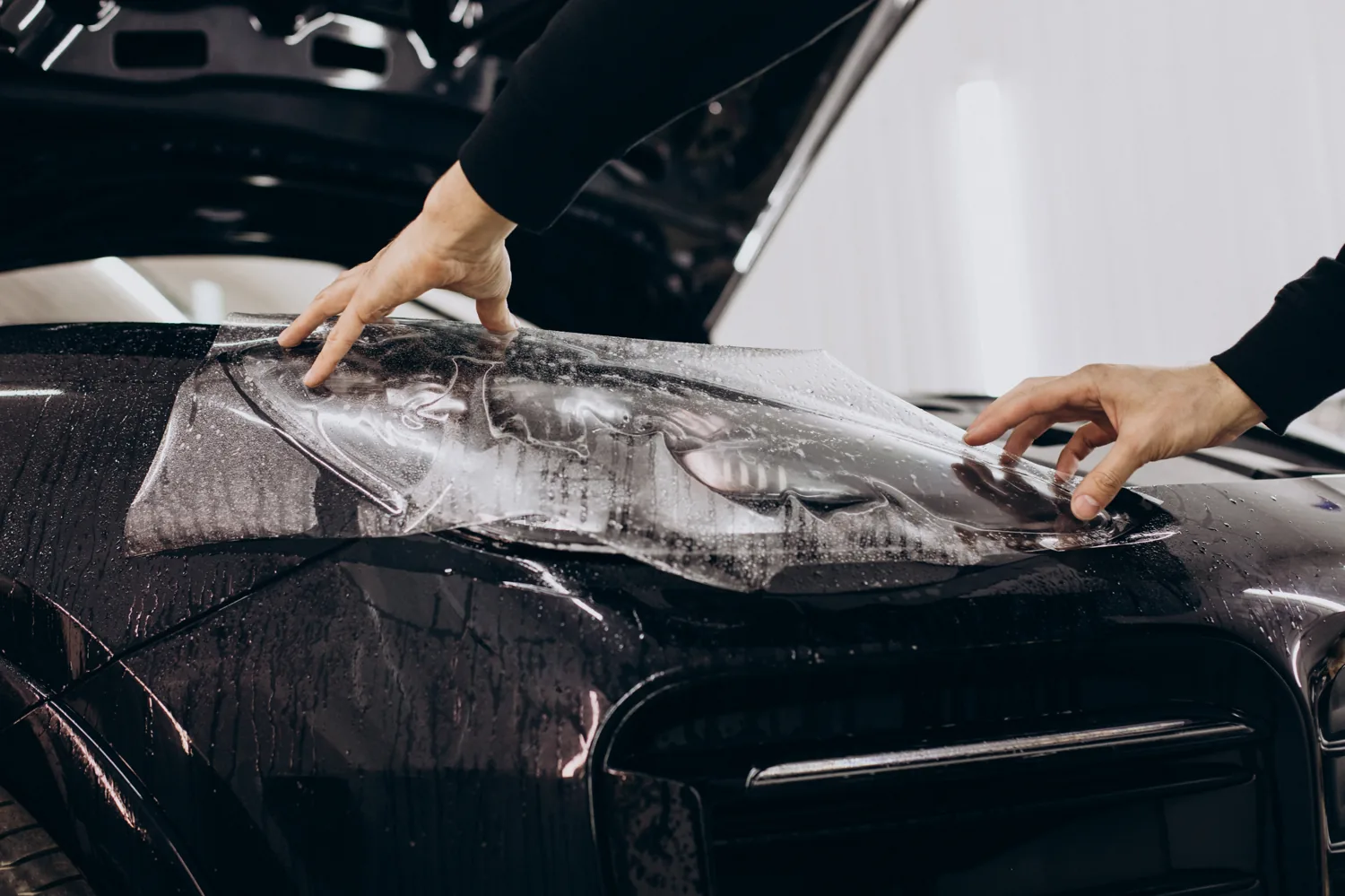 Clear paint protection film going onto a hood